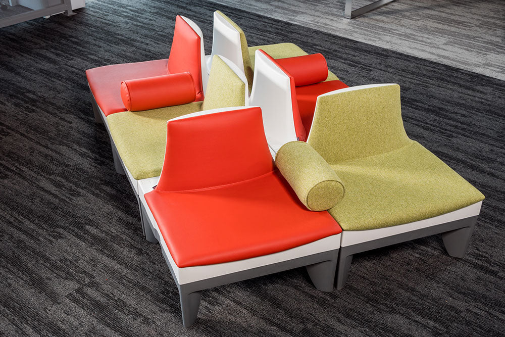 Sofás Sophia en tapizados combinados rojo y verde con cojines cilíndricos descansabrazos
